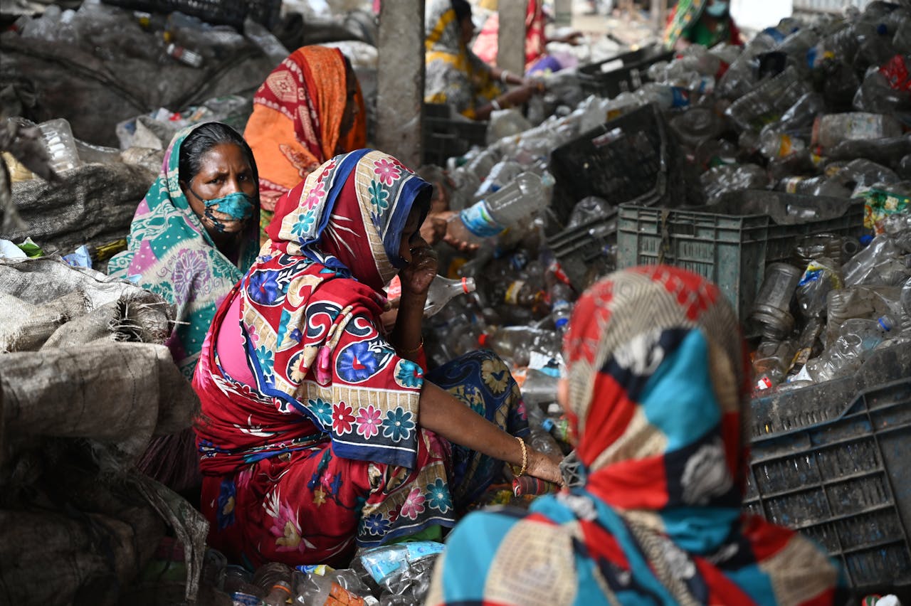 Women recycling plastic bottles in Chattogram, Bangladesh, promoting sustainability.
